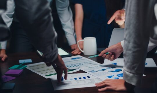 Millennial Asia businessmen and businesswomen meeting brainstorming ideas about new paperwork project colleagues working together planning success strategy enjoy teamwork in small modern night office.